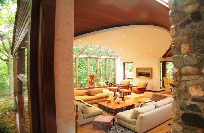 A living room with a lot of furniture and a stone wall