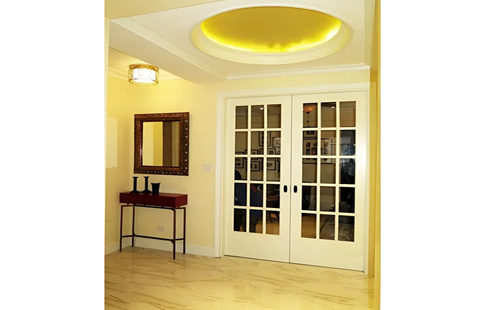 A hallway with french doors and a mirror on the wall