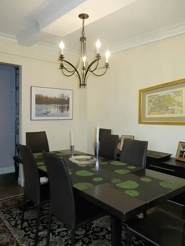 A dining room with a table and chairs and a chandelier
