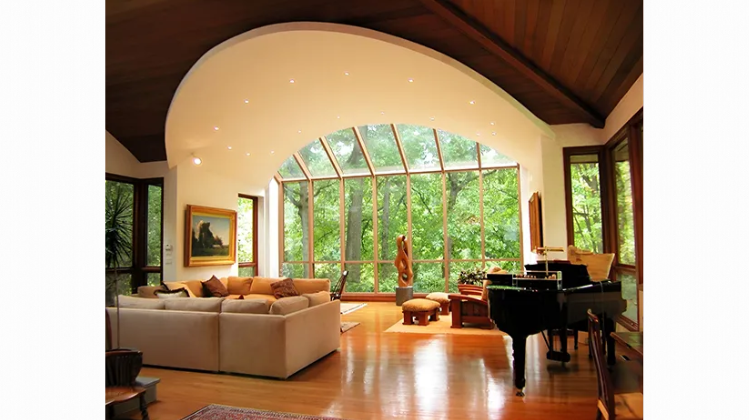 A living room with a piano and lots of windows