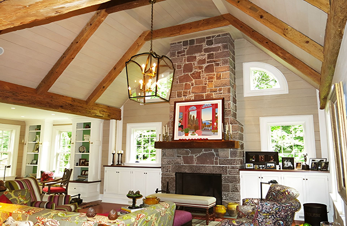 A living room with a vaulted ceiling and a stone fireplace