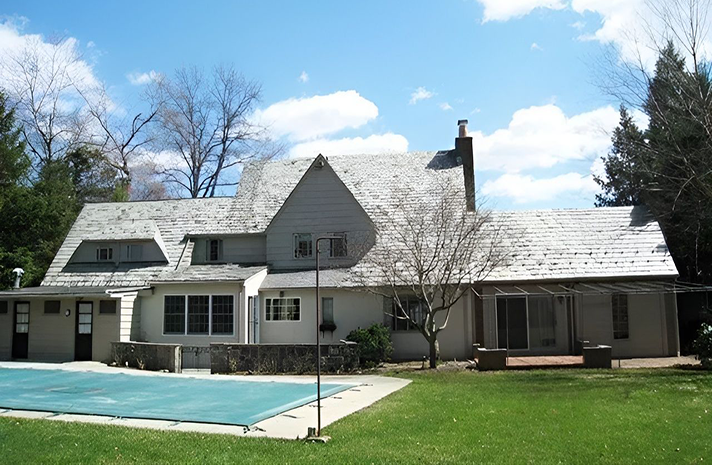 A large house with a swimming pool in front of it