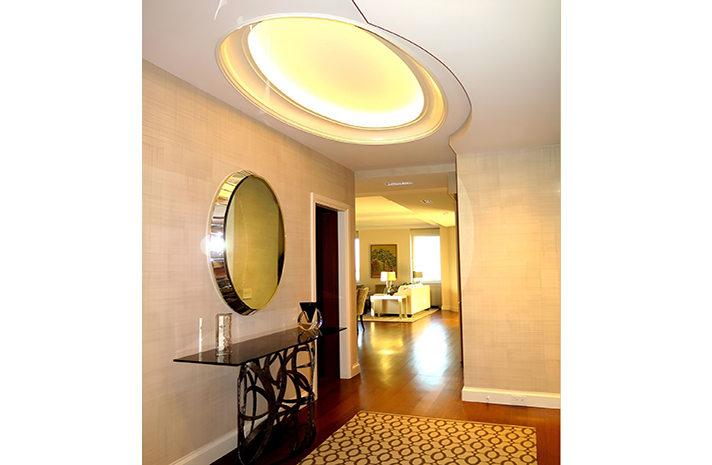 A hallway with a table and a mirror on the wall