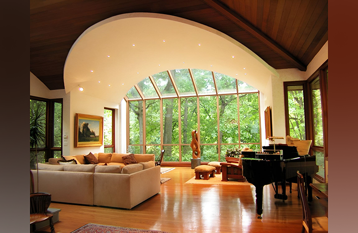 A living room with a piano and lots of windows
