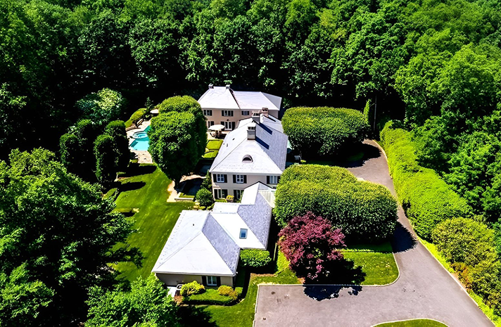 An aerial view of a large house surrounded by trees
