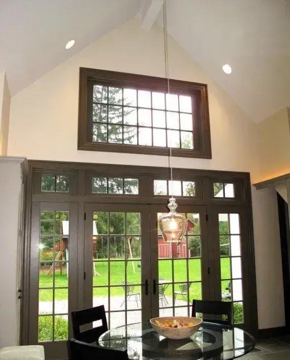 A dining room with a table and chairs and a large window