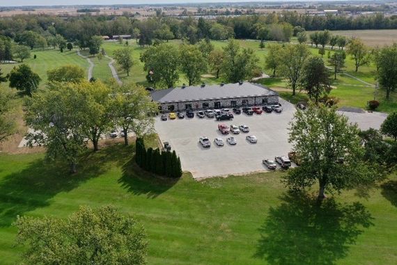 An aerial view of a golf course with a lot of cars parked in the parking lot.