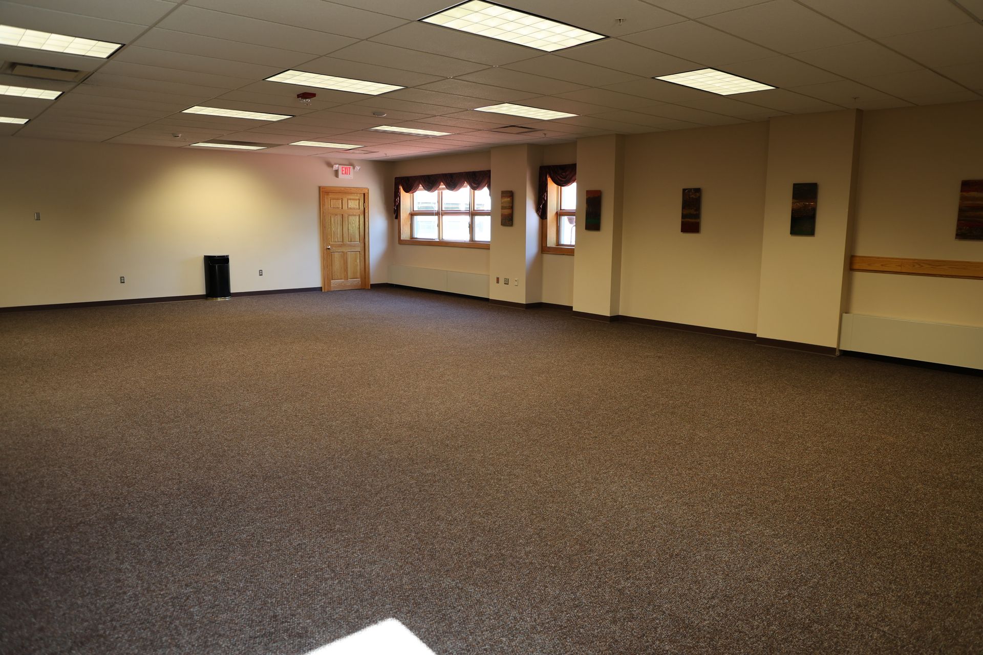 An empty meeting room with a brown carpet and white walls.
