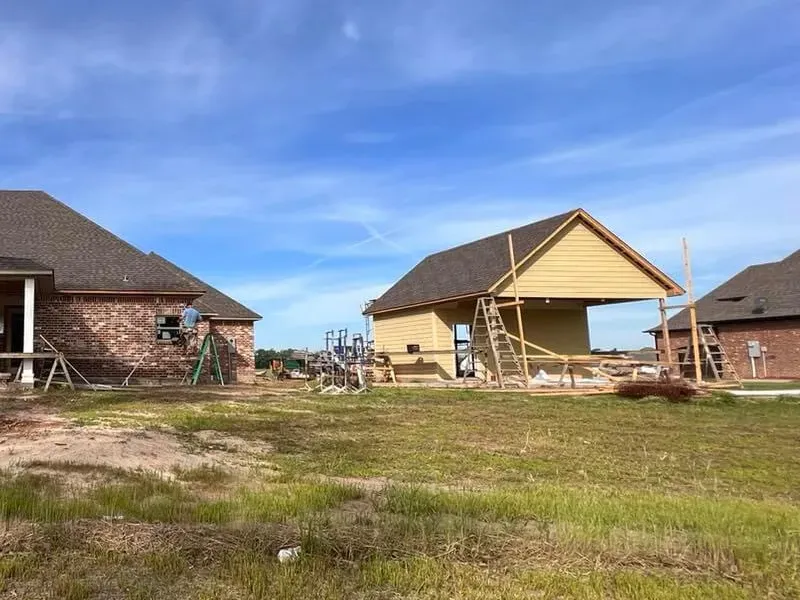 A couple of houses that are being built in a field.