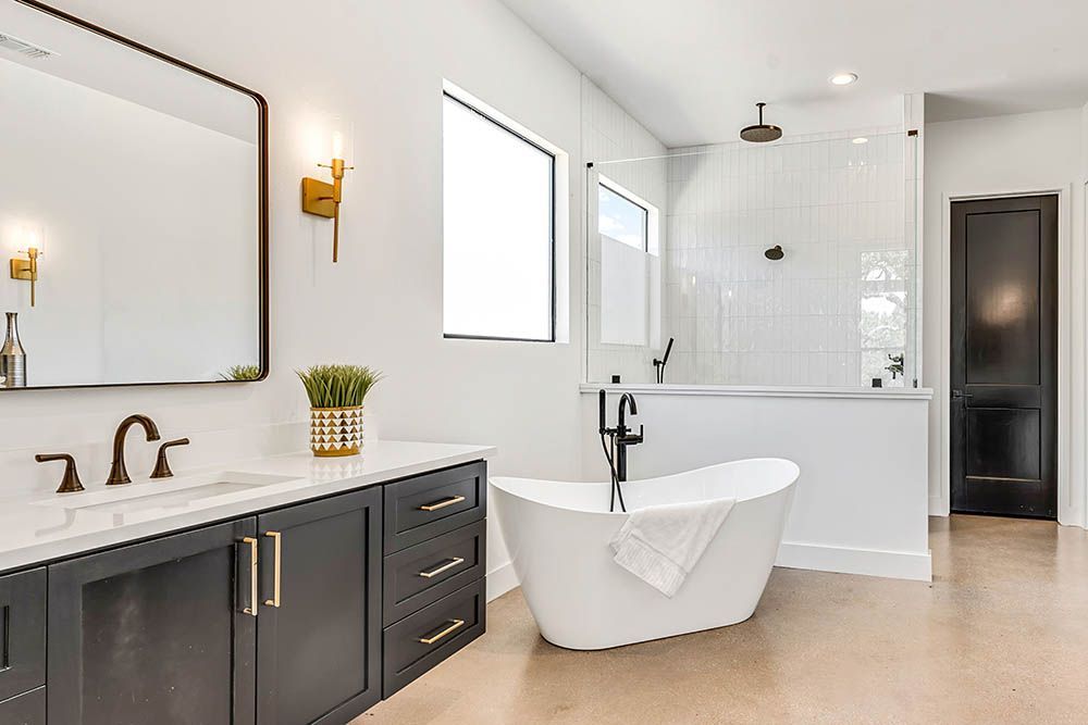A bathroom with a bathtub , sink , mirror and walk in shower.