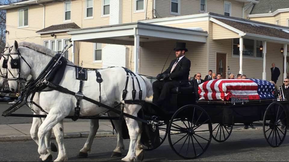 Horse drawn caisson with flag draped casket