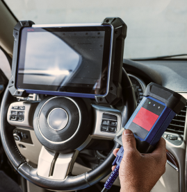 Handheld payment terminal near a mounted tablet on a car steering wheel dashboard setup