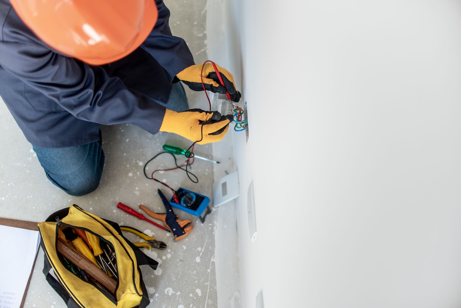 A man is testing the electricity with a multimeter.