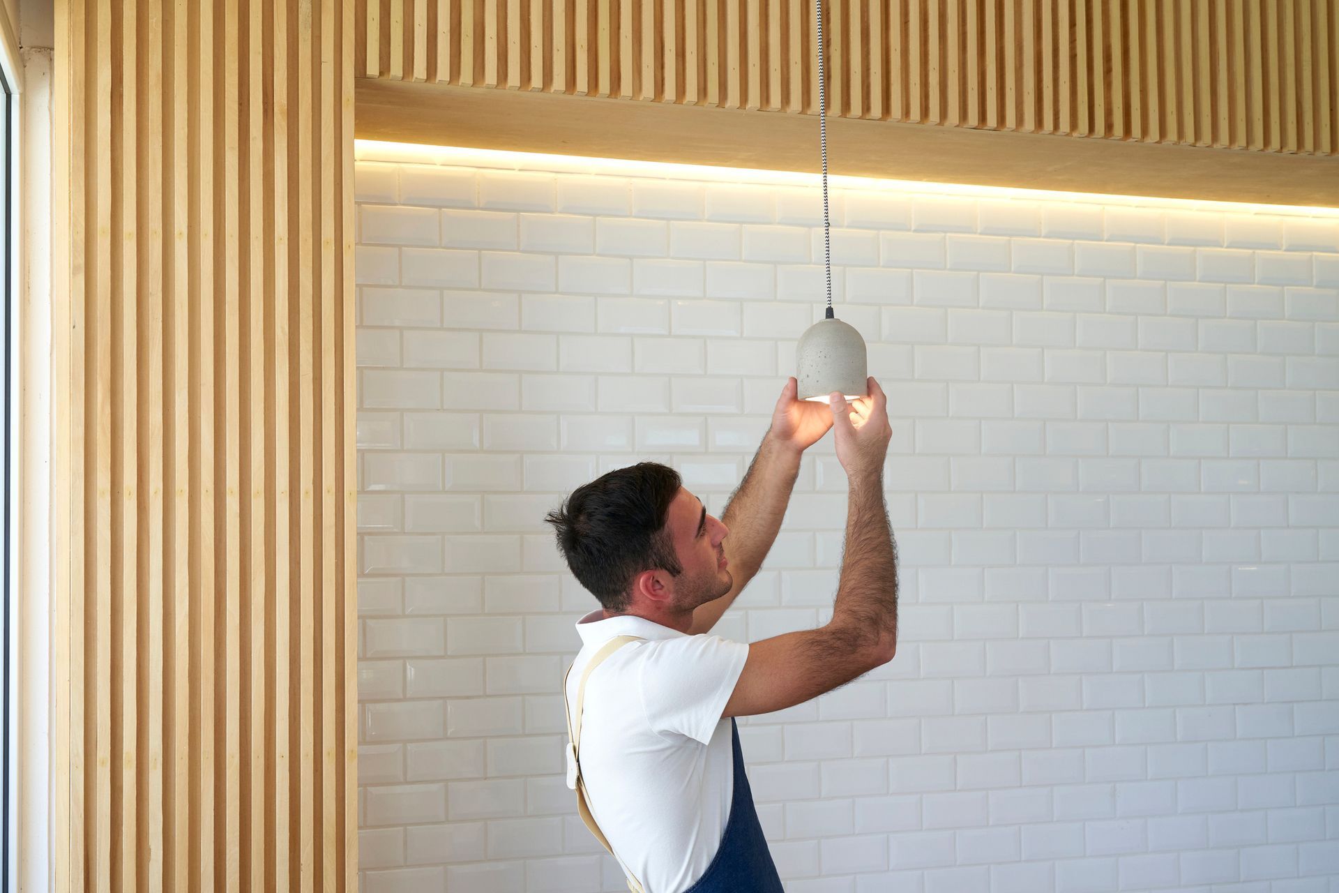 A man is changing a lightbulb.