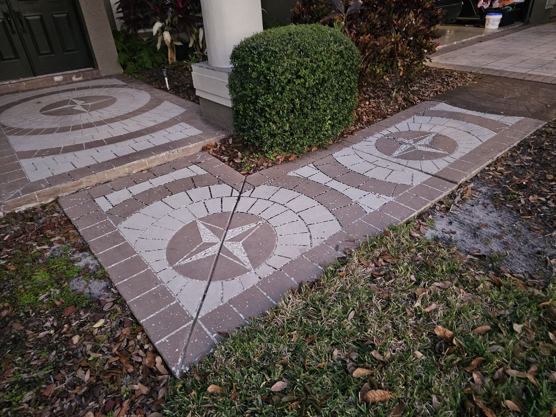 Brick pathway with compass rose design leading to a front door.
