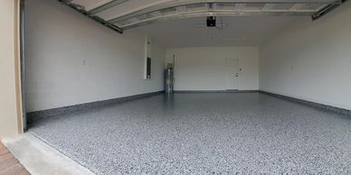 An empty garage with a gray floor and white walls.
