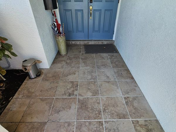 A front entryway with tile flooring, a blue door, and white walls.