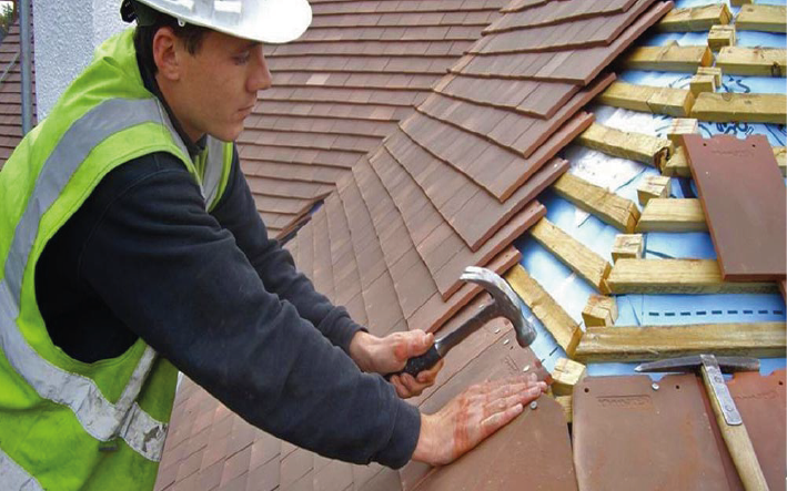 man fitting a new tiled roof