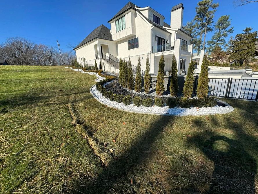 flowerbeds with evergreen trees and white gravel