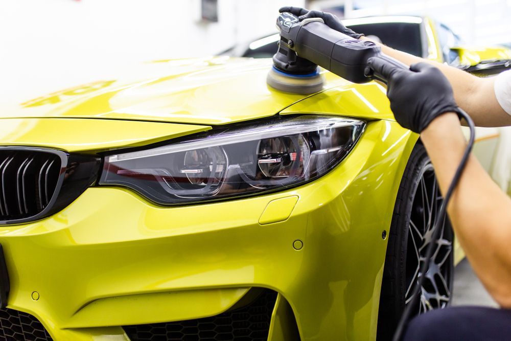 A Man Is Polishing a Yellow Car with A Machine — Jetty Car Detailing Coffs Harbour in Coffs Harbour NSW