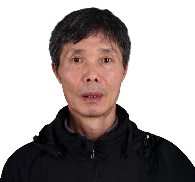 A man wearing a black jacket with a hood looks at the camera