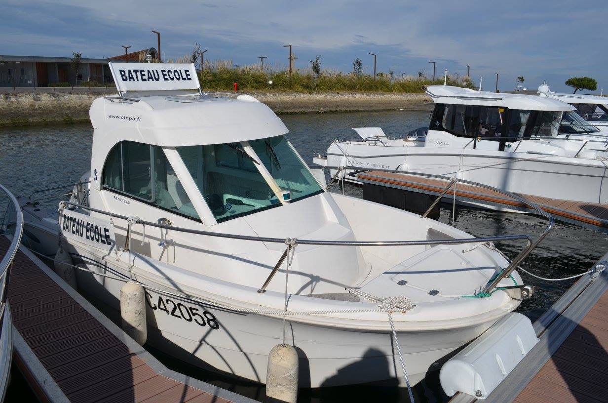 Un bateau blanc est amarré dans une marina à côté d'un quai.