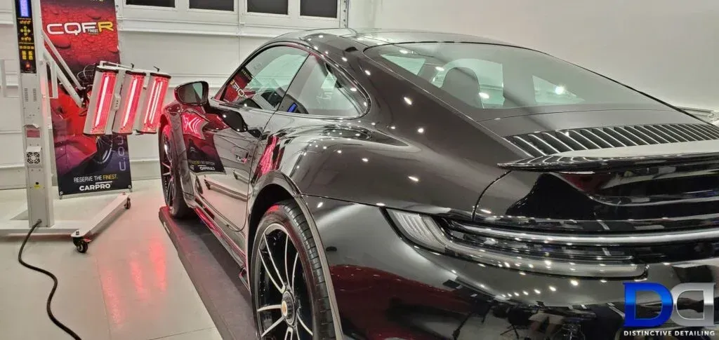 A black sports car is parked in a garage.