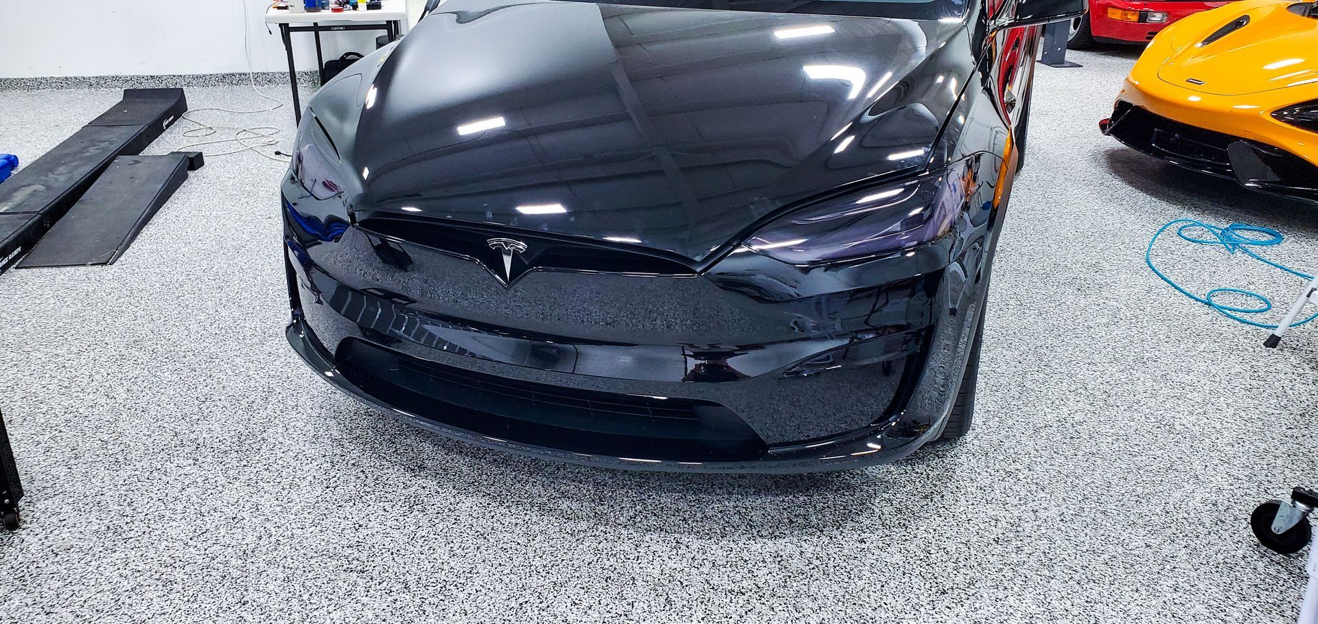 Yellow Ford Mustang headlight, close-up, with a sleek, modern design and black accents.