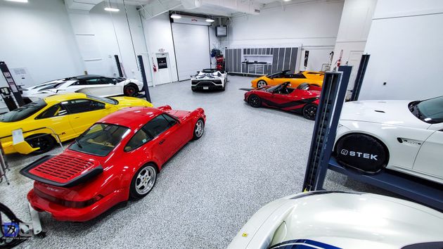 A bunch of cars are parked in a garage.