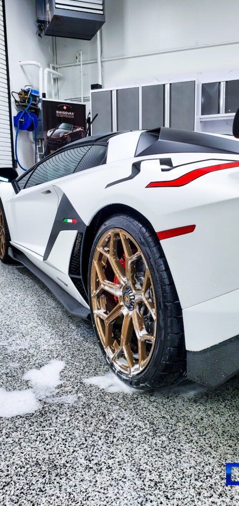 A white lamborghini aventador is parked in a garage.