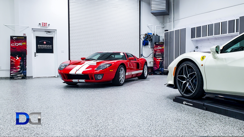 Red Ford GT and white Ferrari in a clean, modern garage setting.