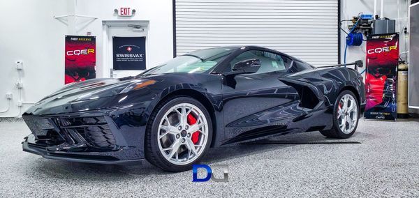 Dark blue sports car in a garage with red brake calipers.