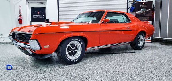 Orange classic car in a garage.