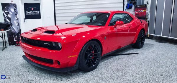 Red Dodge Challenger in a garage.