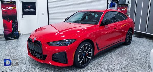 Red BMW 4 series coupe parked inside a garage, with the front of the car facing towards the camera.