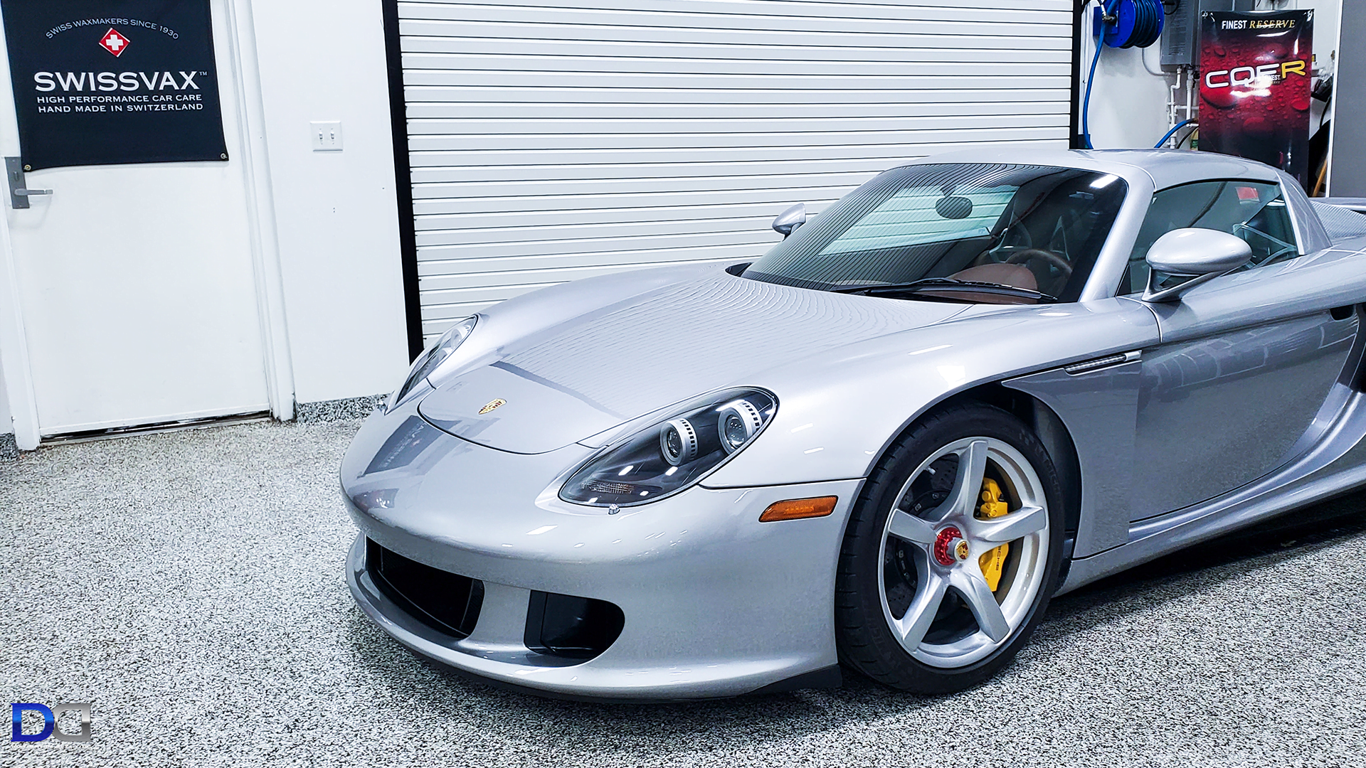 A silver sports car is parked in a garage.