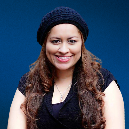 A woman wearing a black hat and a black shirt smiles for the camera