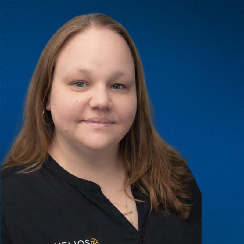 A woman with long hair is wearing a black shirt and earrings.