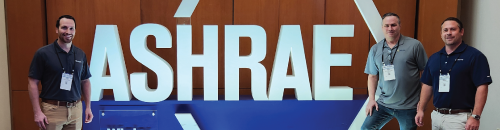 A group of men standing in front of a sign that says ashrae