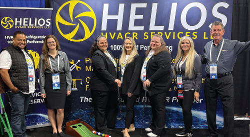 A group of people are standing in front of a helios banner.