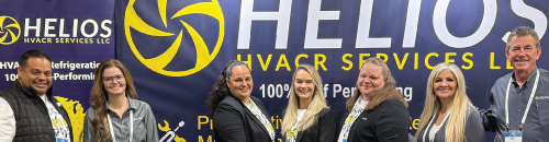 A group of people standing in front of a helios sign.