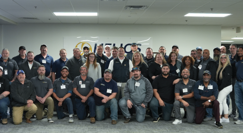 A large group of people are posing for a picture in a room.