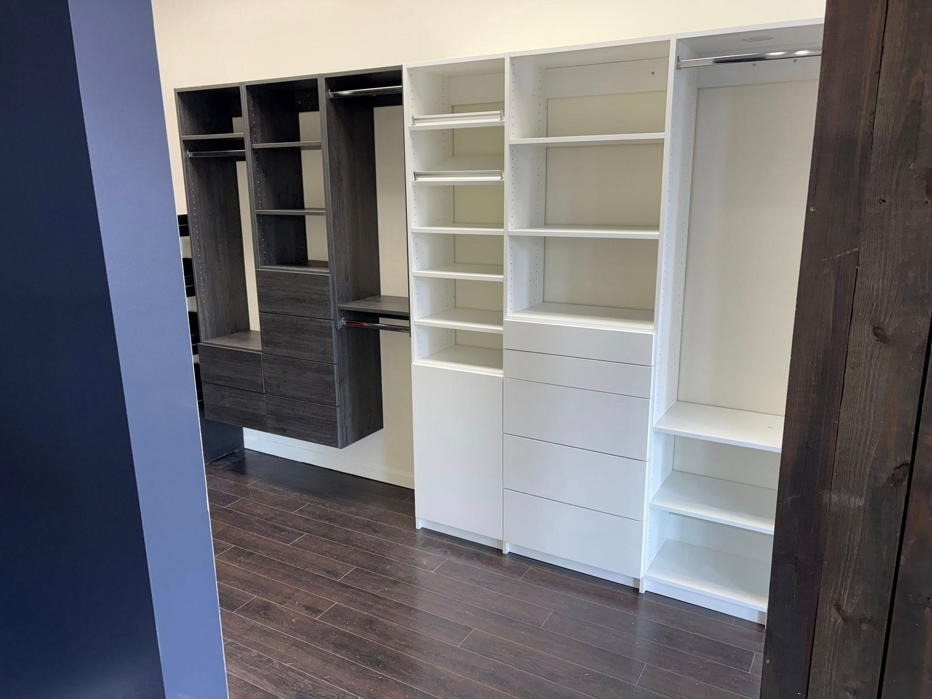 Custom closet organizers, white and dark gray, with drawers, shelves, and hanging rods.