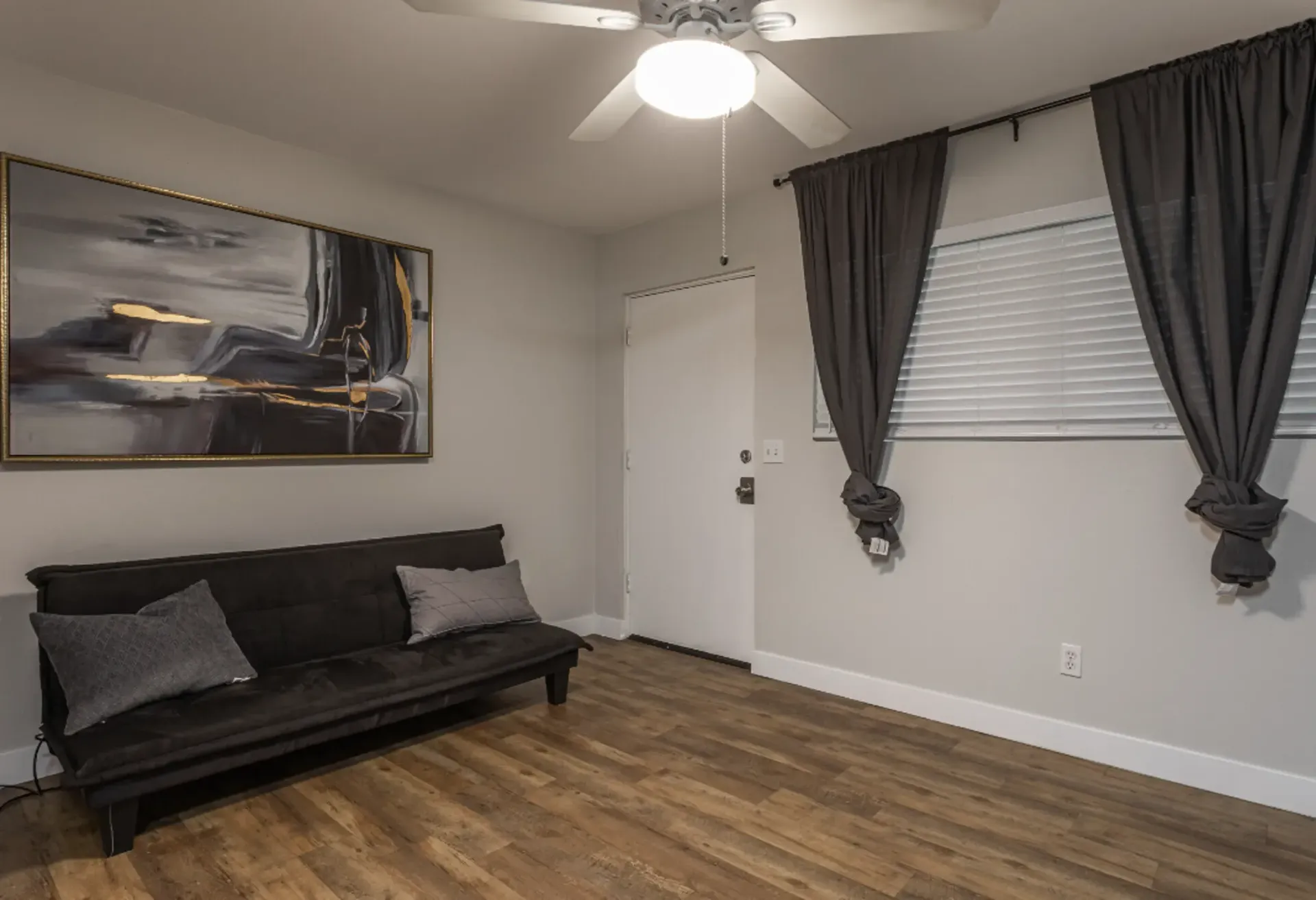 a room with a couch and a painting on the wall