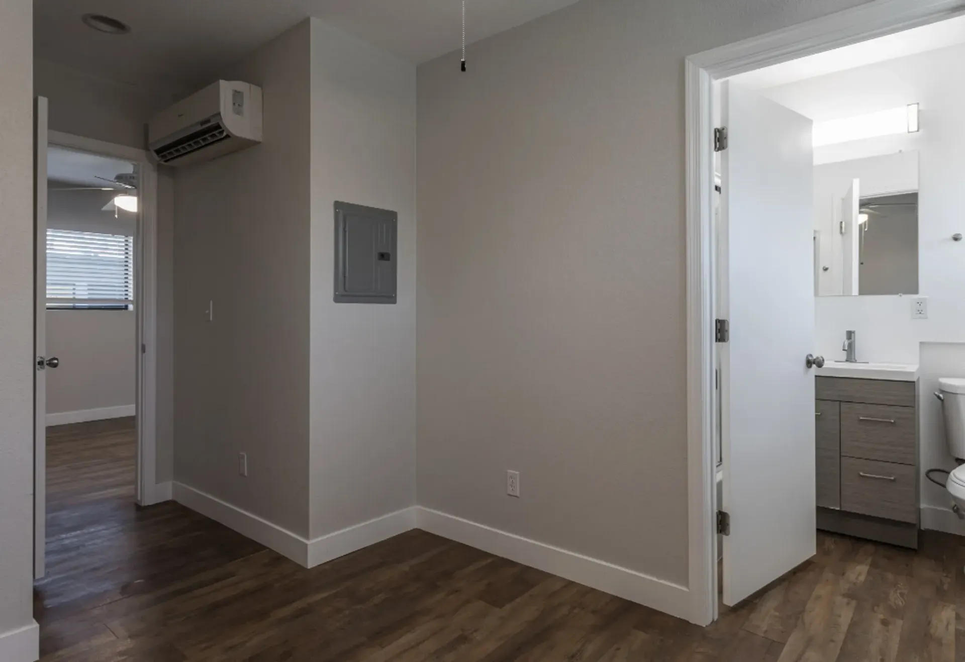 a hallway leading to a bathroom with a toilet and sink