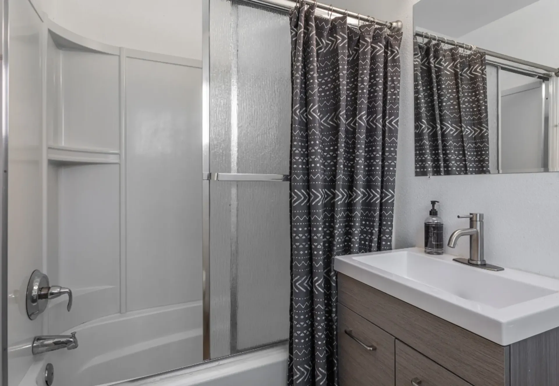 a bathroom with a gray shower curtain and a sink