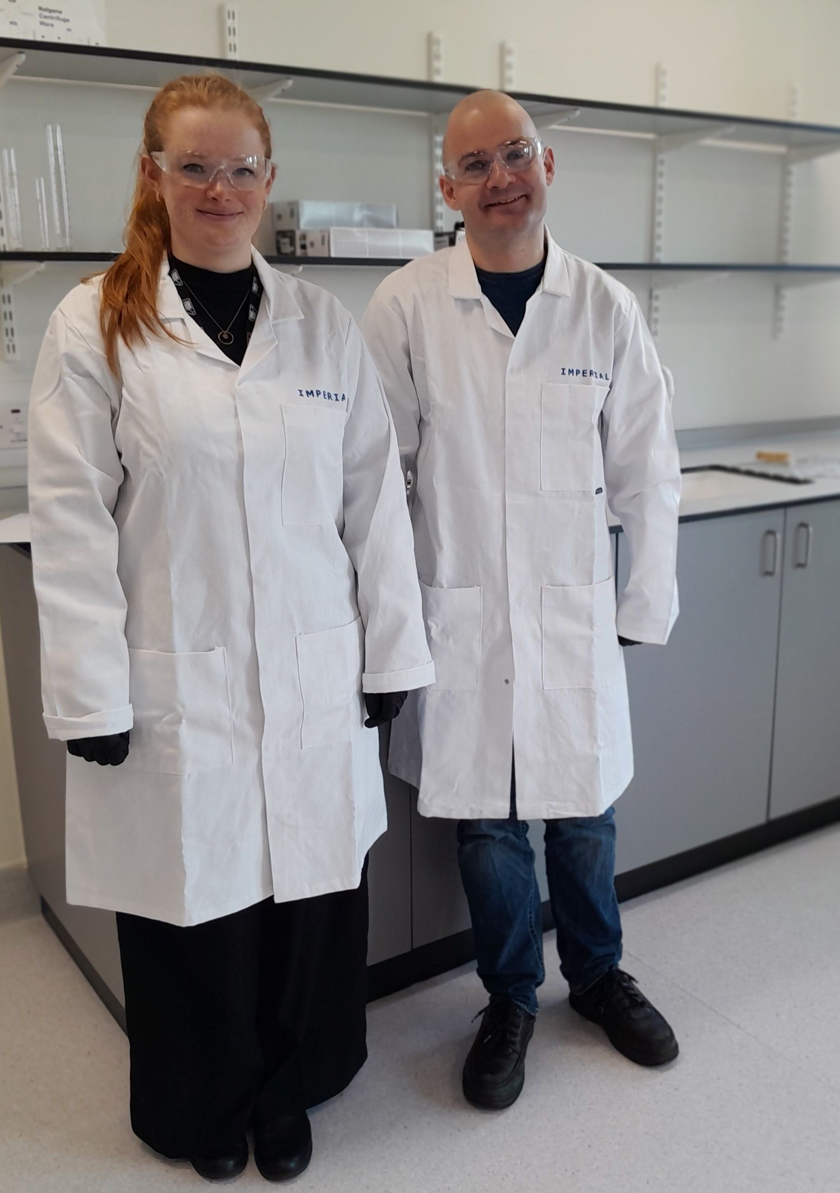 A man and a woman in lab coats are standing next to each other