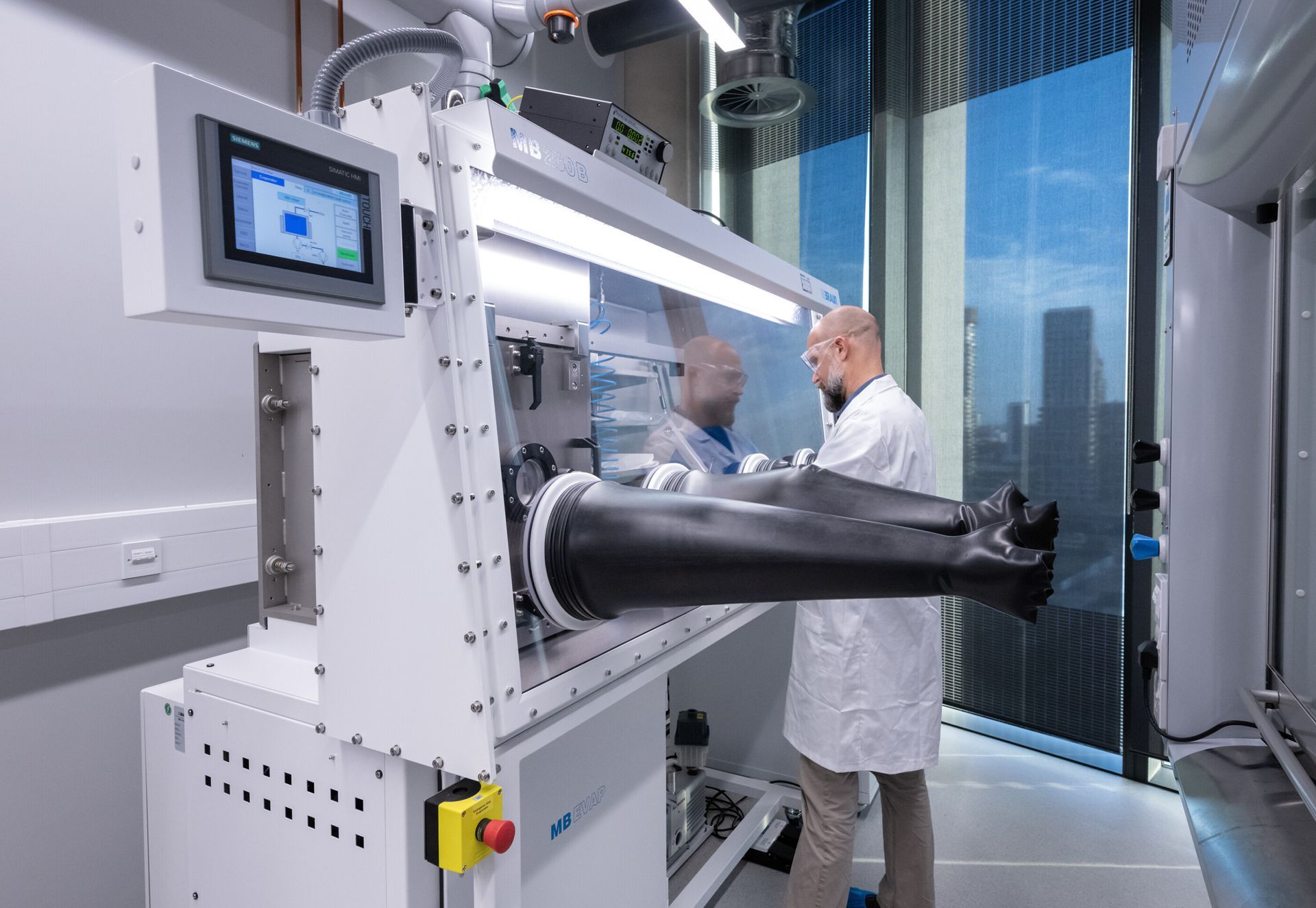 A man in a lab coat is working on a machine.