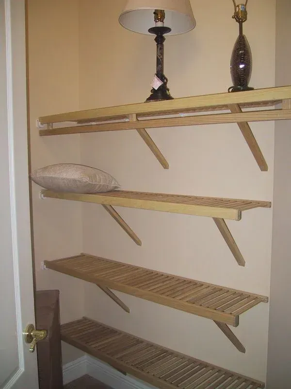 A closet with shelves and a lamp on top