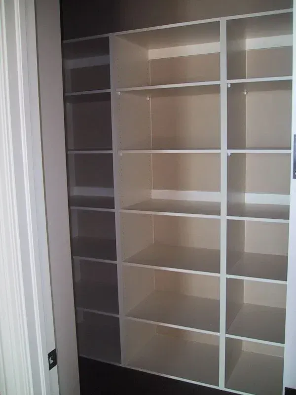 A closet with lots of shelves and a door